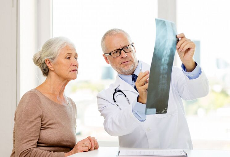The doctor diagnoses cervical osteochondrosis in a patient using an X-ray